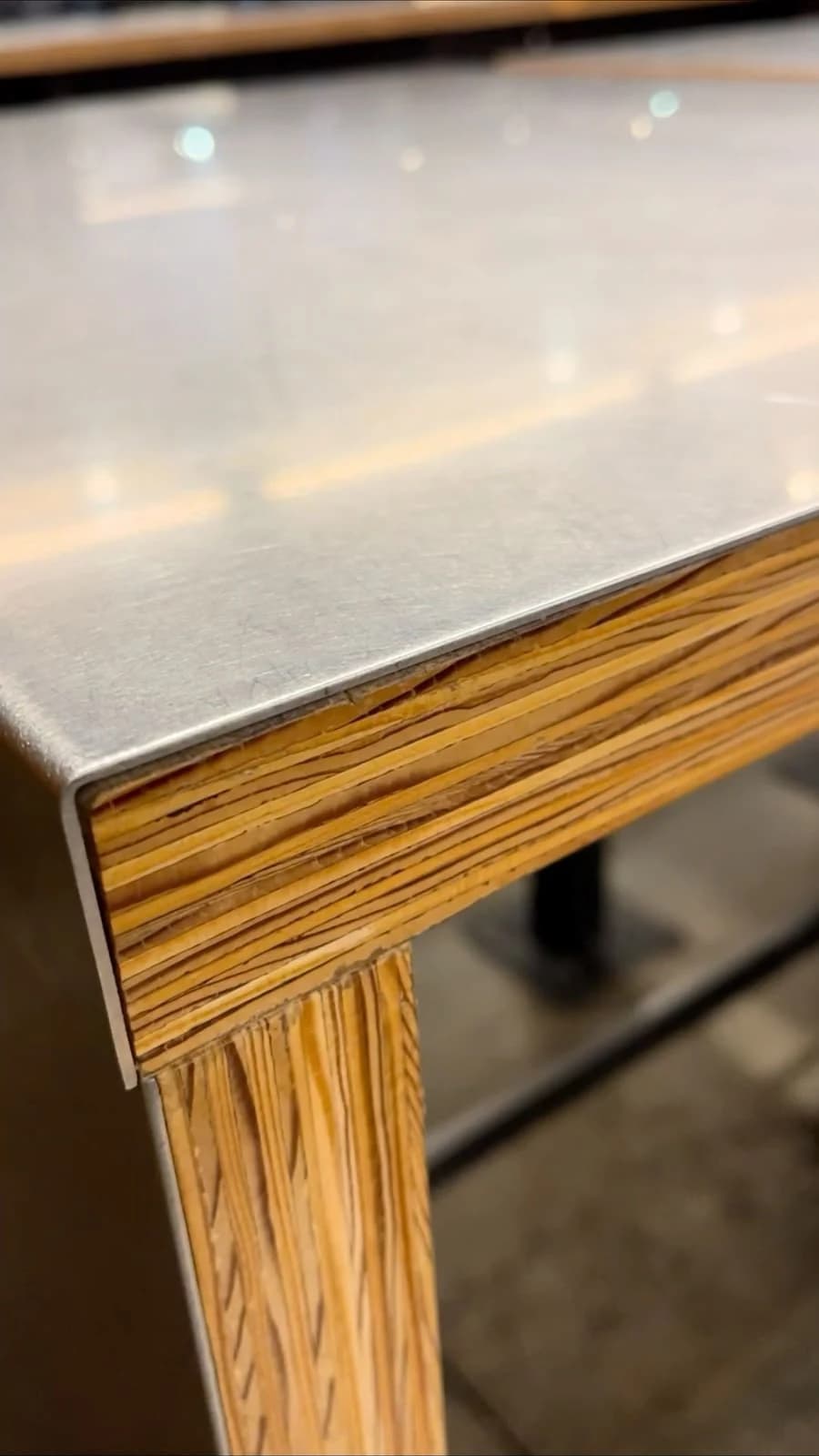Close-up of a stainless steel surface over a layered timber support